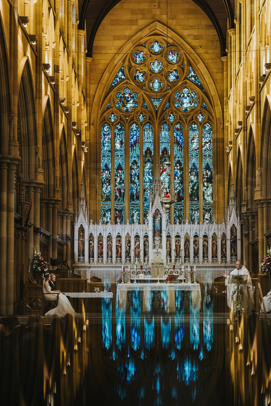 Couple at the altar beneath the stained glass of St Mary's Cathedral