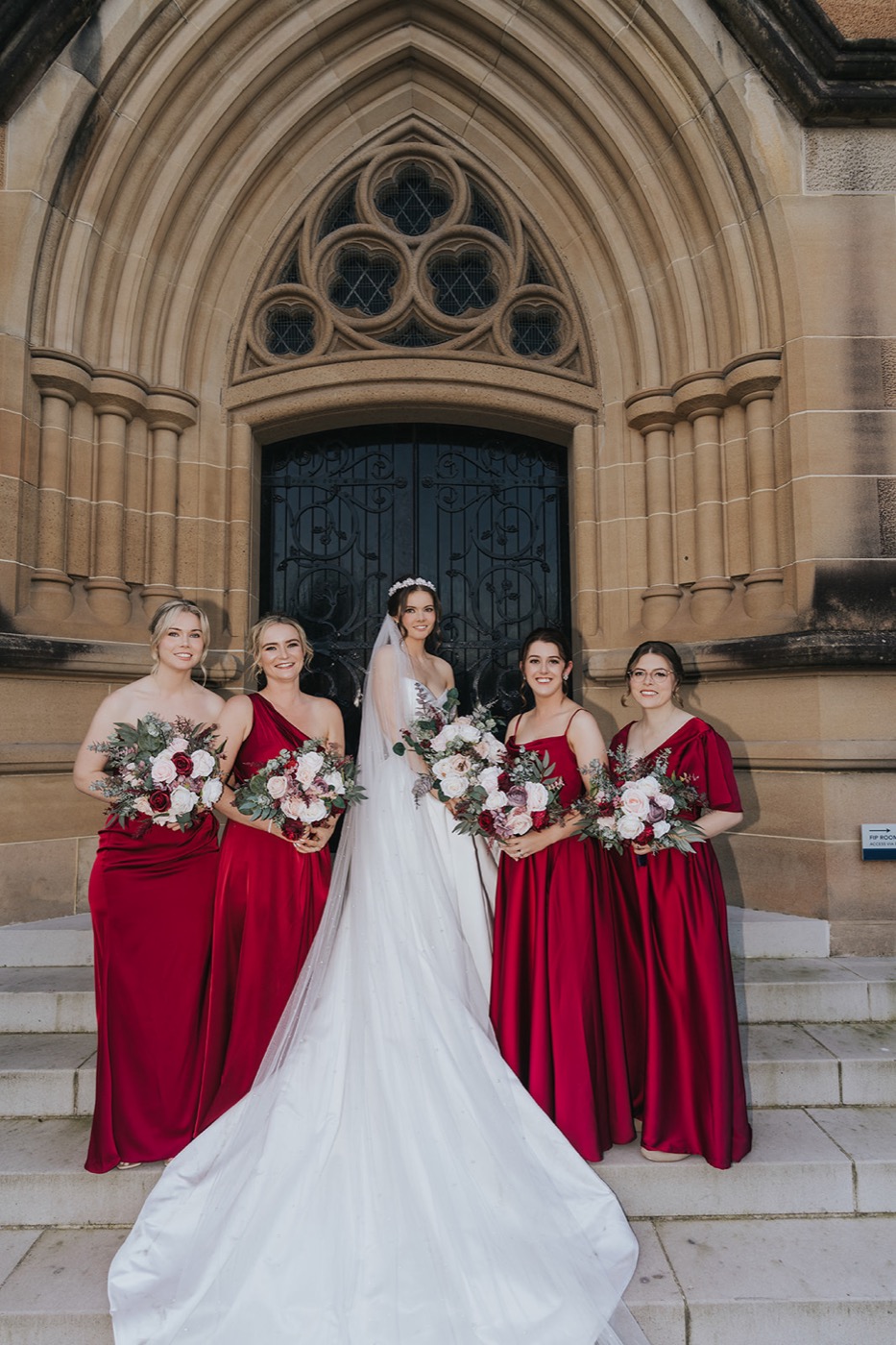 Bridal party in red at the cathedral doors