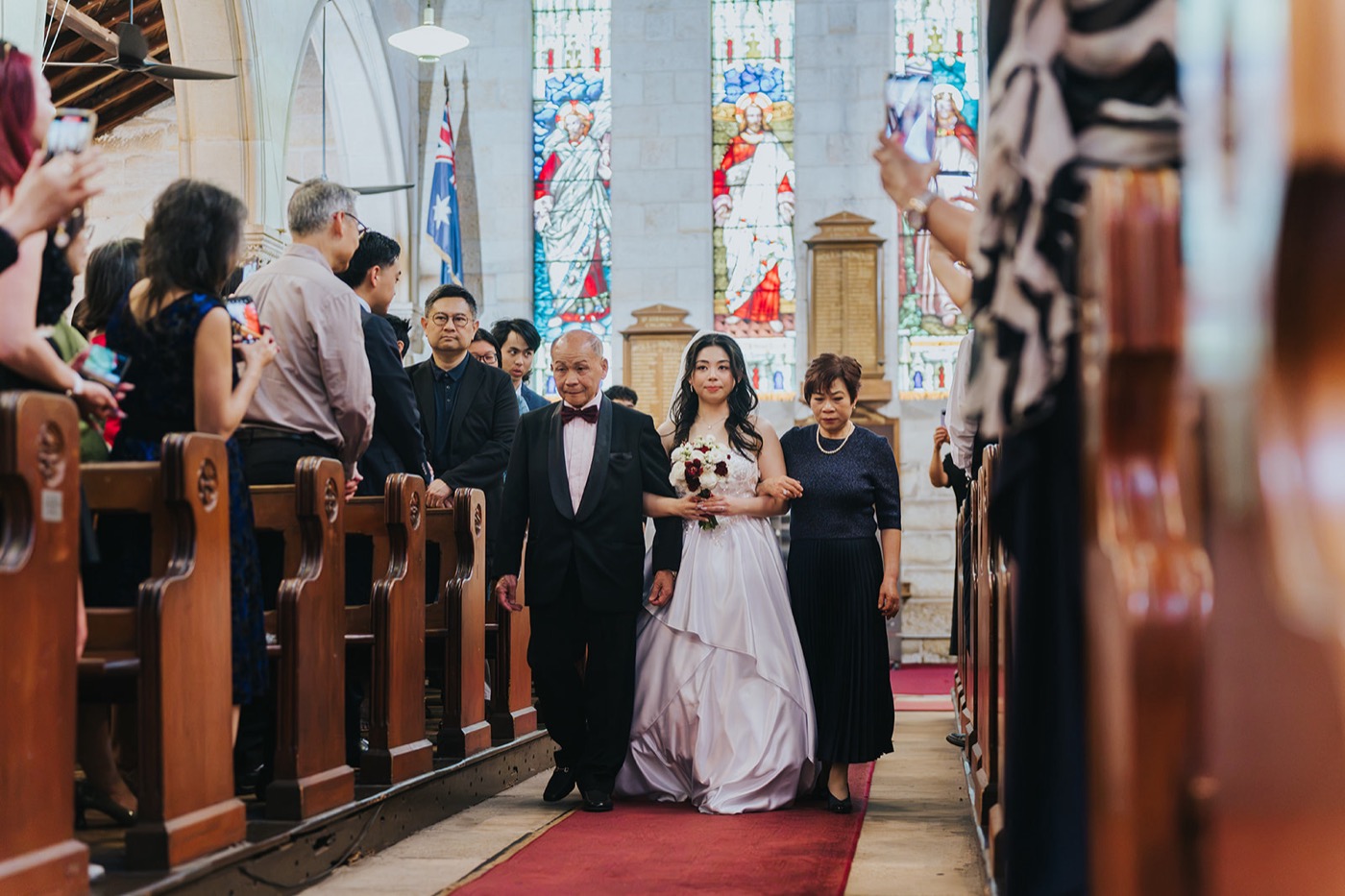 Bride walking down the aisle past stained glass windows