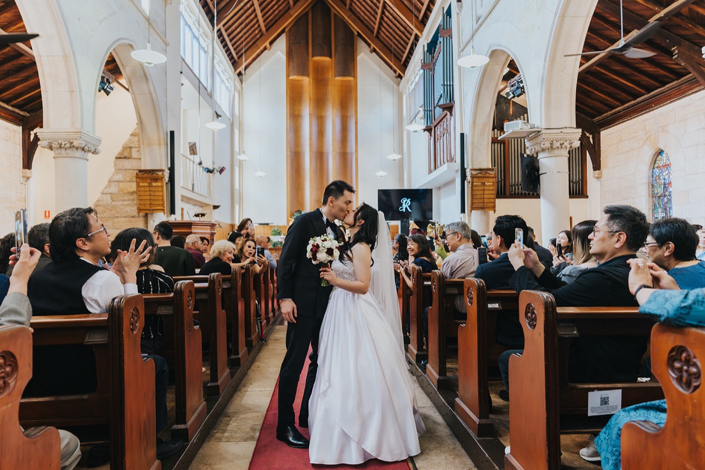 Newlyweds walking back down the aisle as the congregation cheers