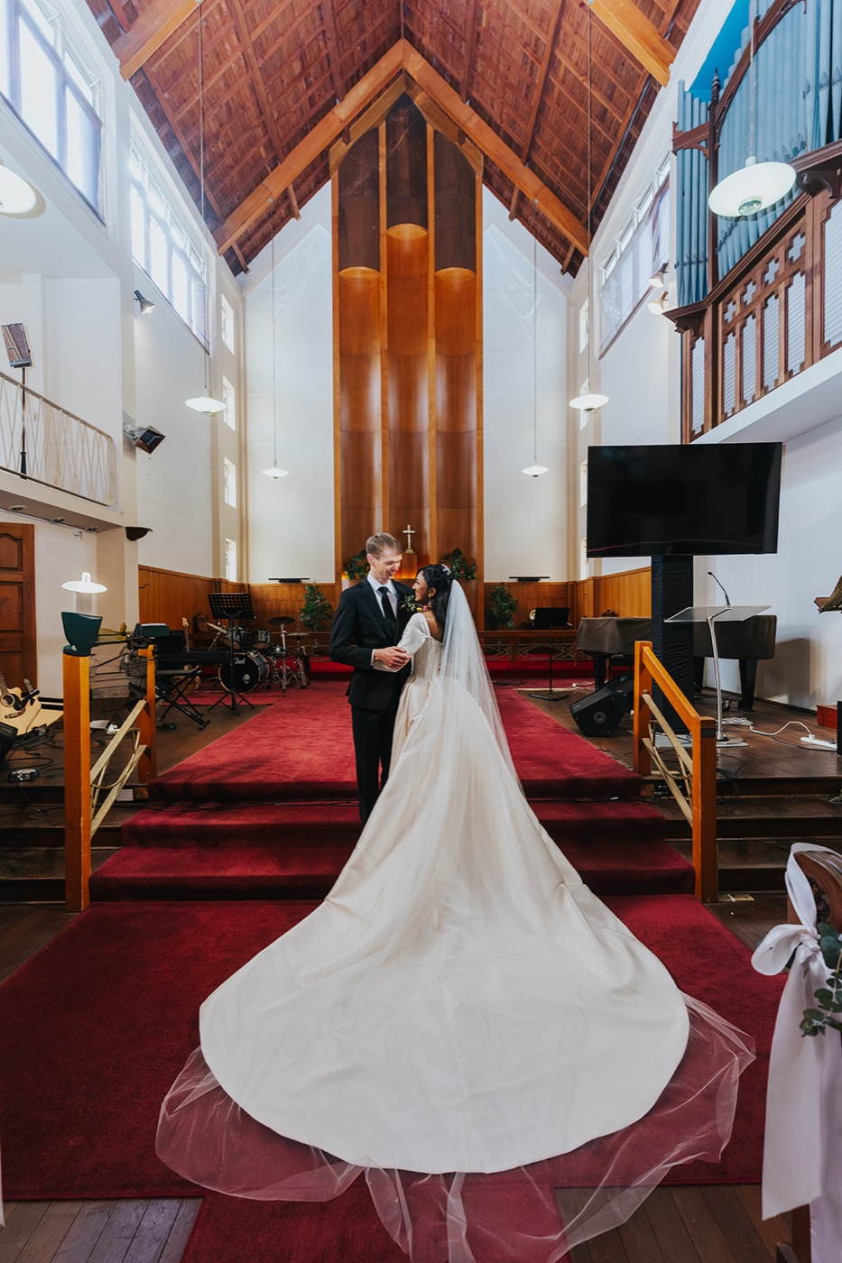 Bride's train on the red carpet of the church aisle