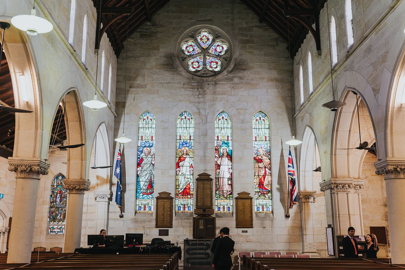 Stained glass windows behind the sanctuary of a sandstone church
