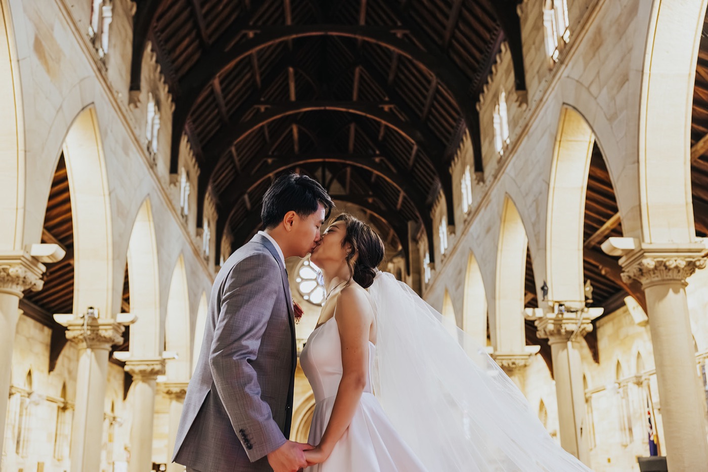 Couple's first kiss beneath the church arches