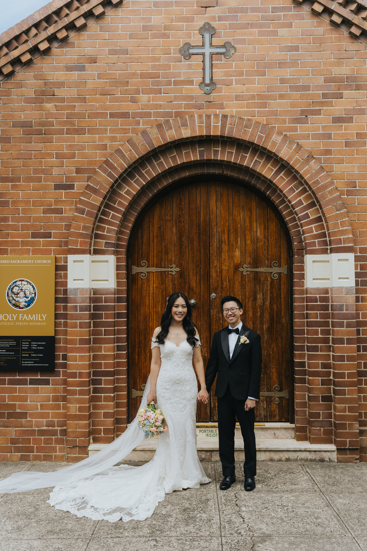 Couple at the arched timber doors of Holy Family church, Mosman