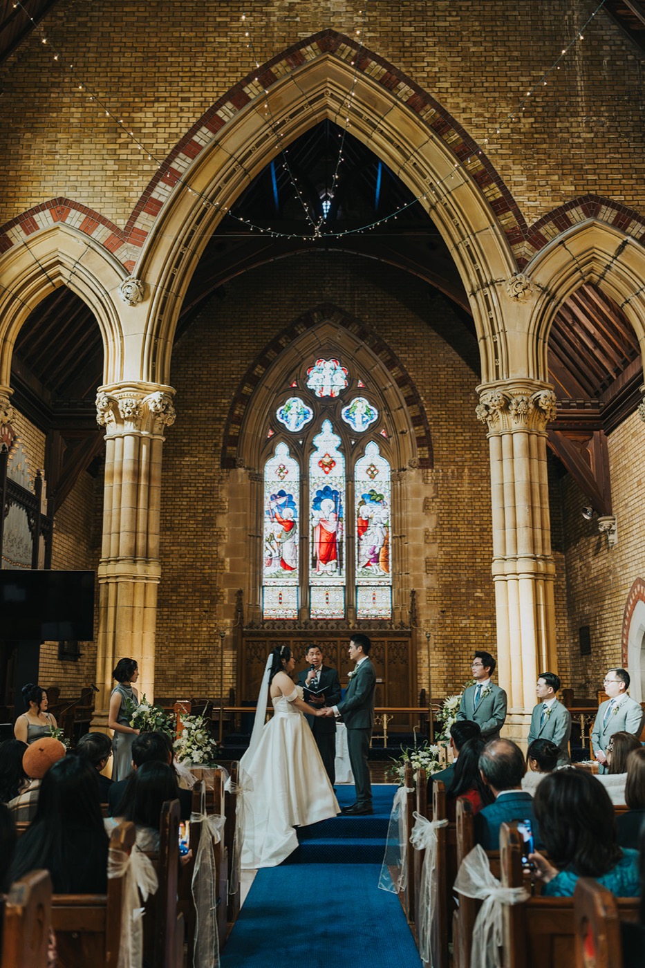 Bride and groom beneath the church's gothic arches