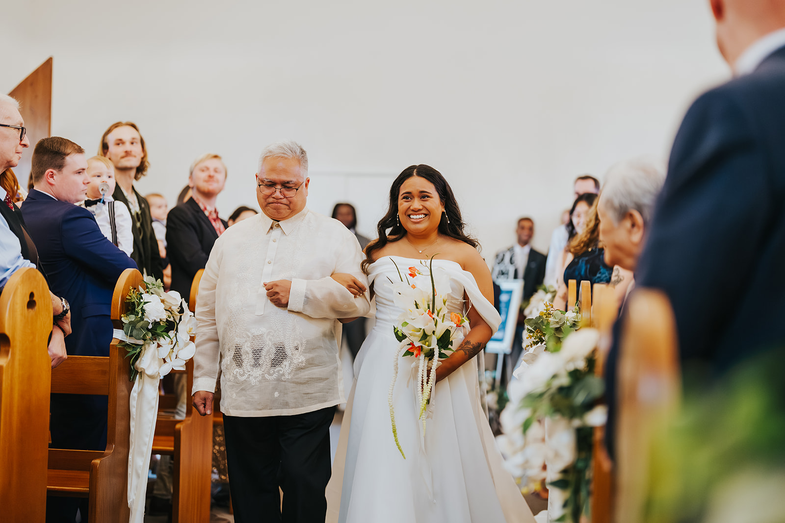 Sophia walking down the aisle arm in arm with family