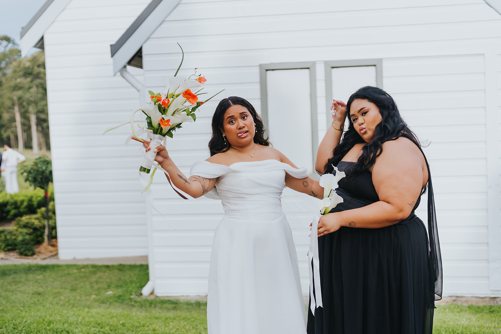 Bridesmaids in black gowns with Sophia on the chapel lawn