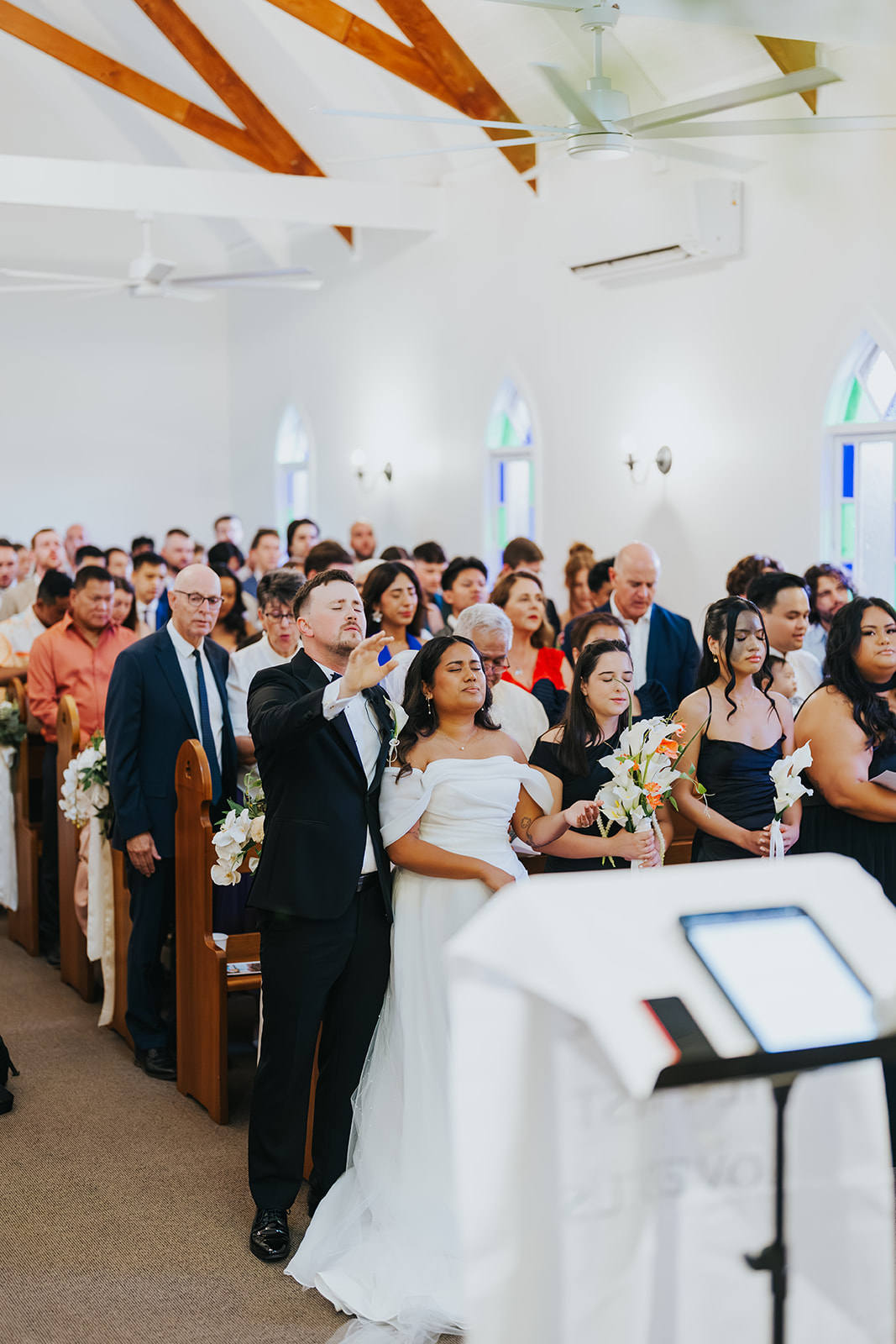 Guests standing in the white chapel during the ceremony