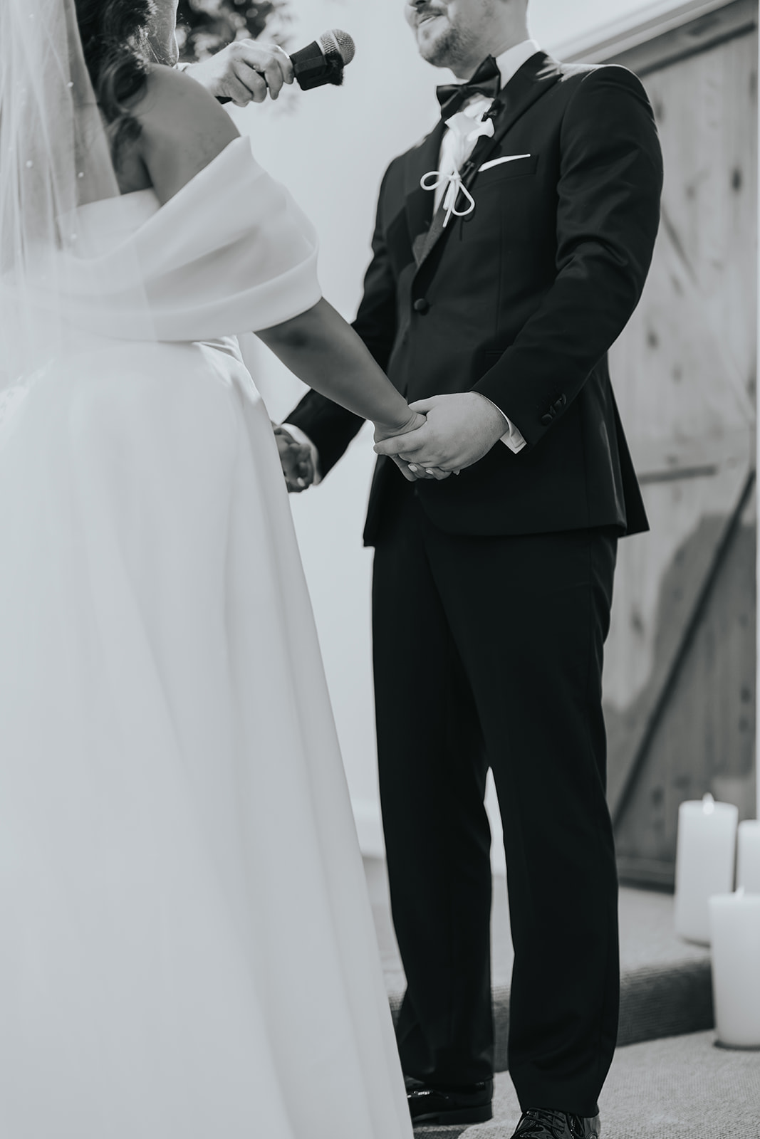 Black and white of Lachlan placing the ring on Sophia's finger