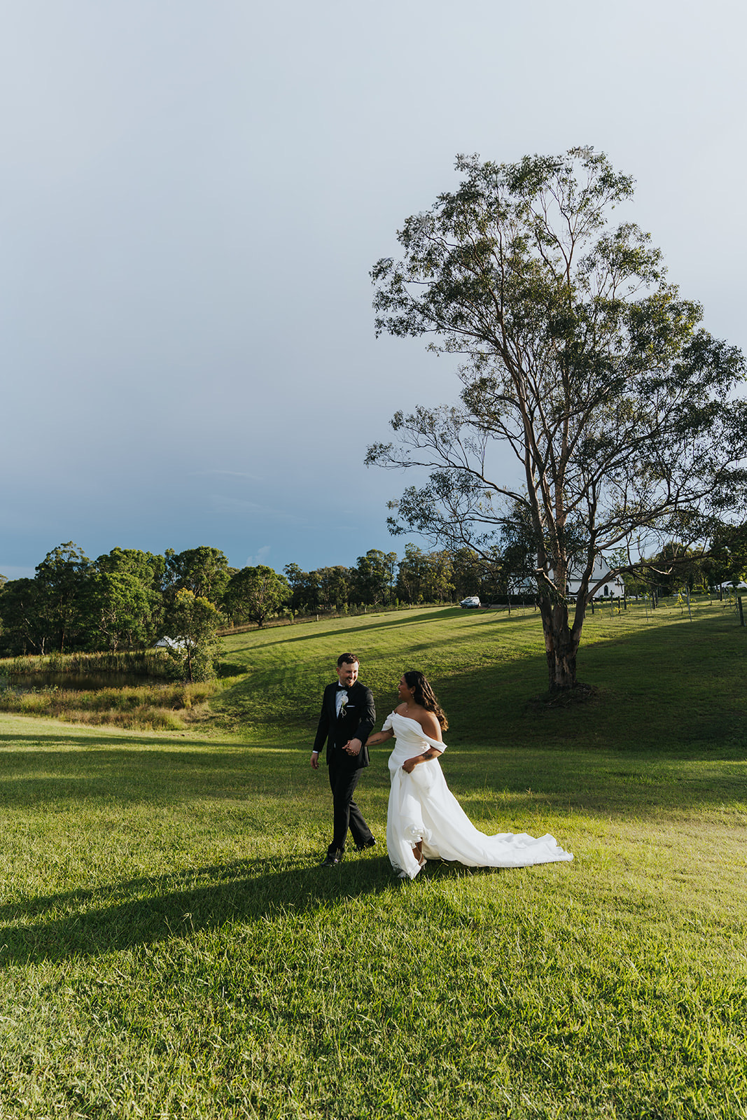 Sophia and Lachlan on a grassy hill beside a lone tree