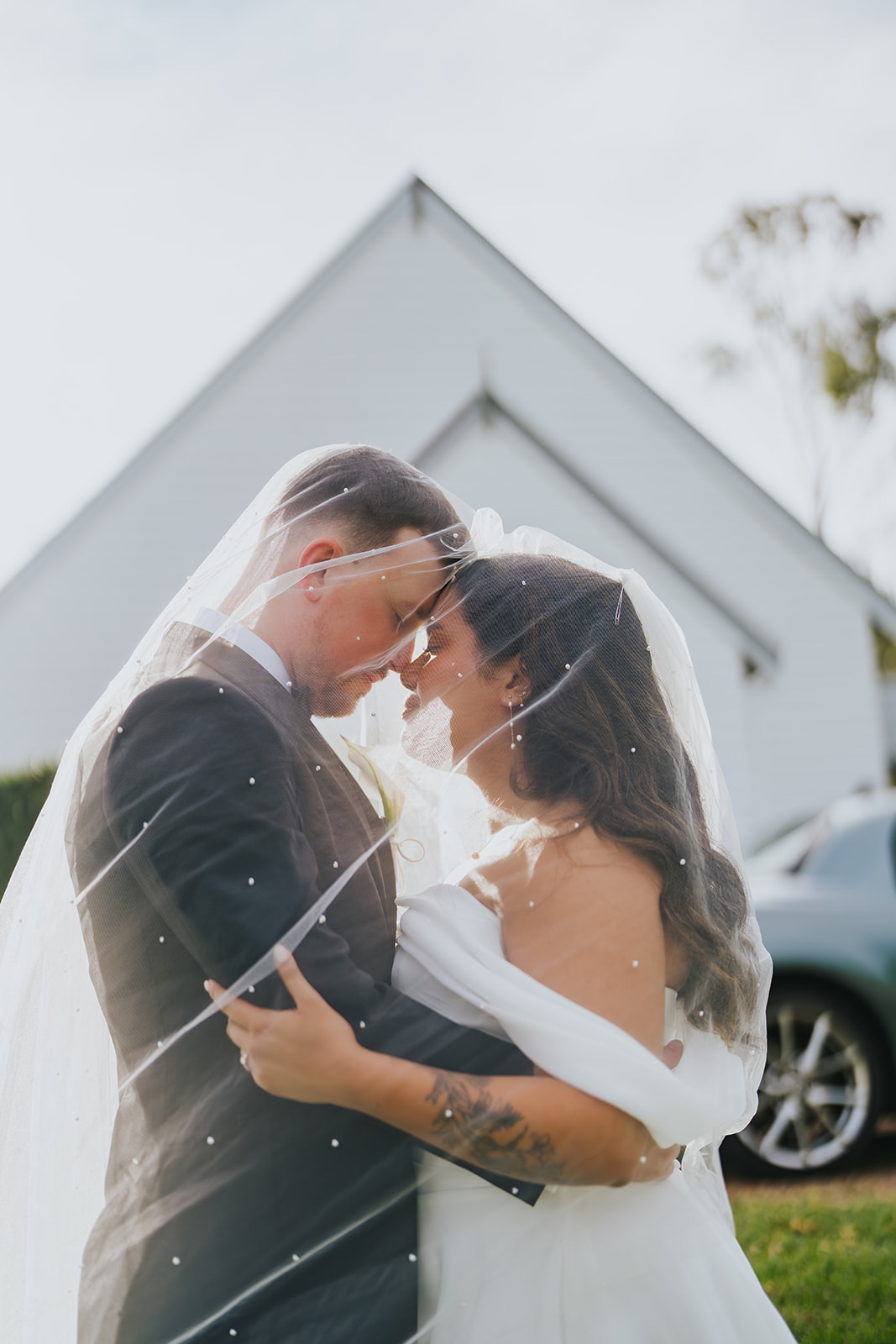 Sophia and Lachlan under her veil beside the chapel