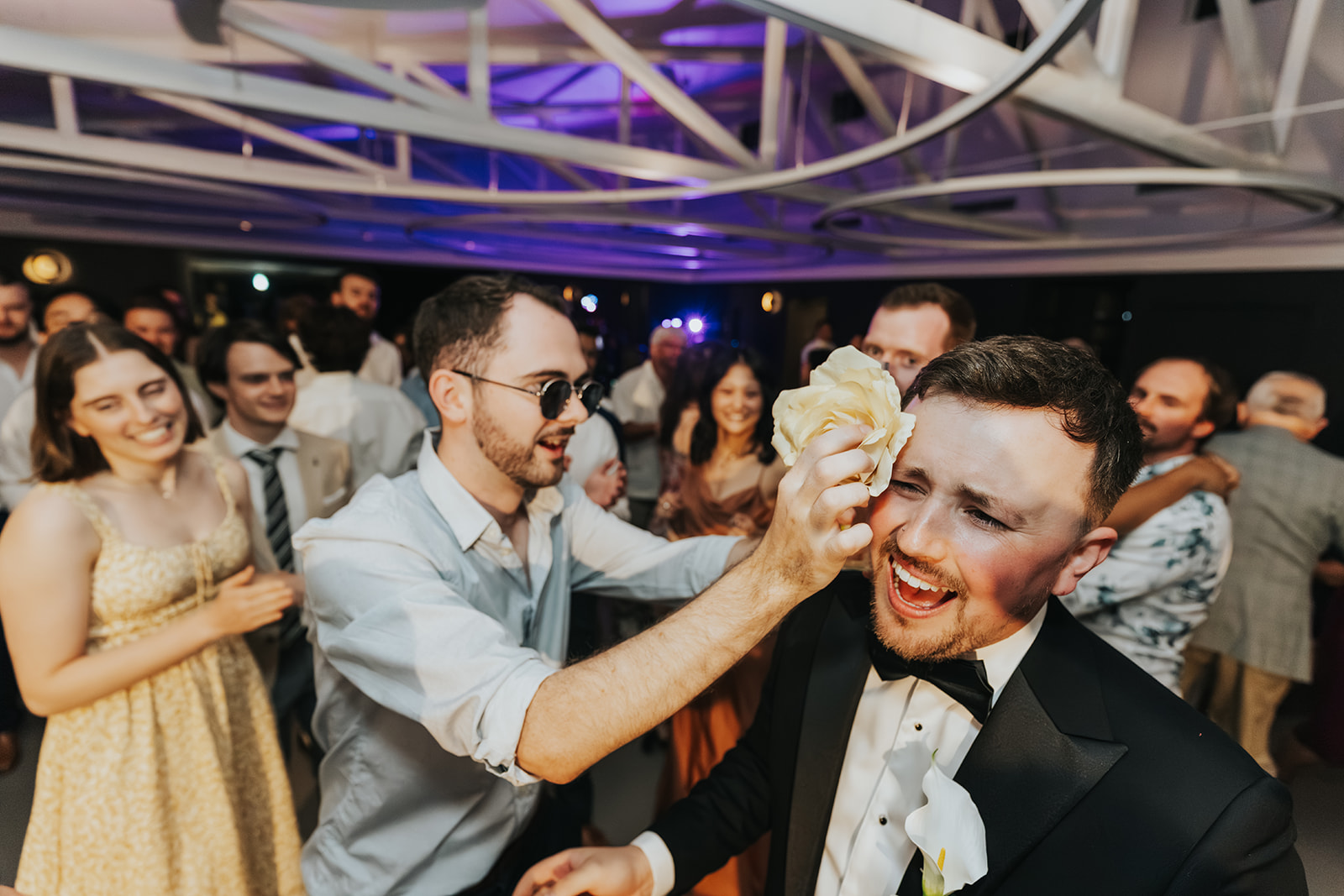 Guests dancing together under the reception lights