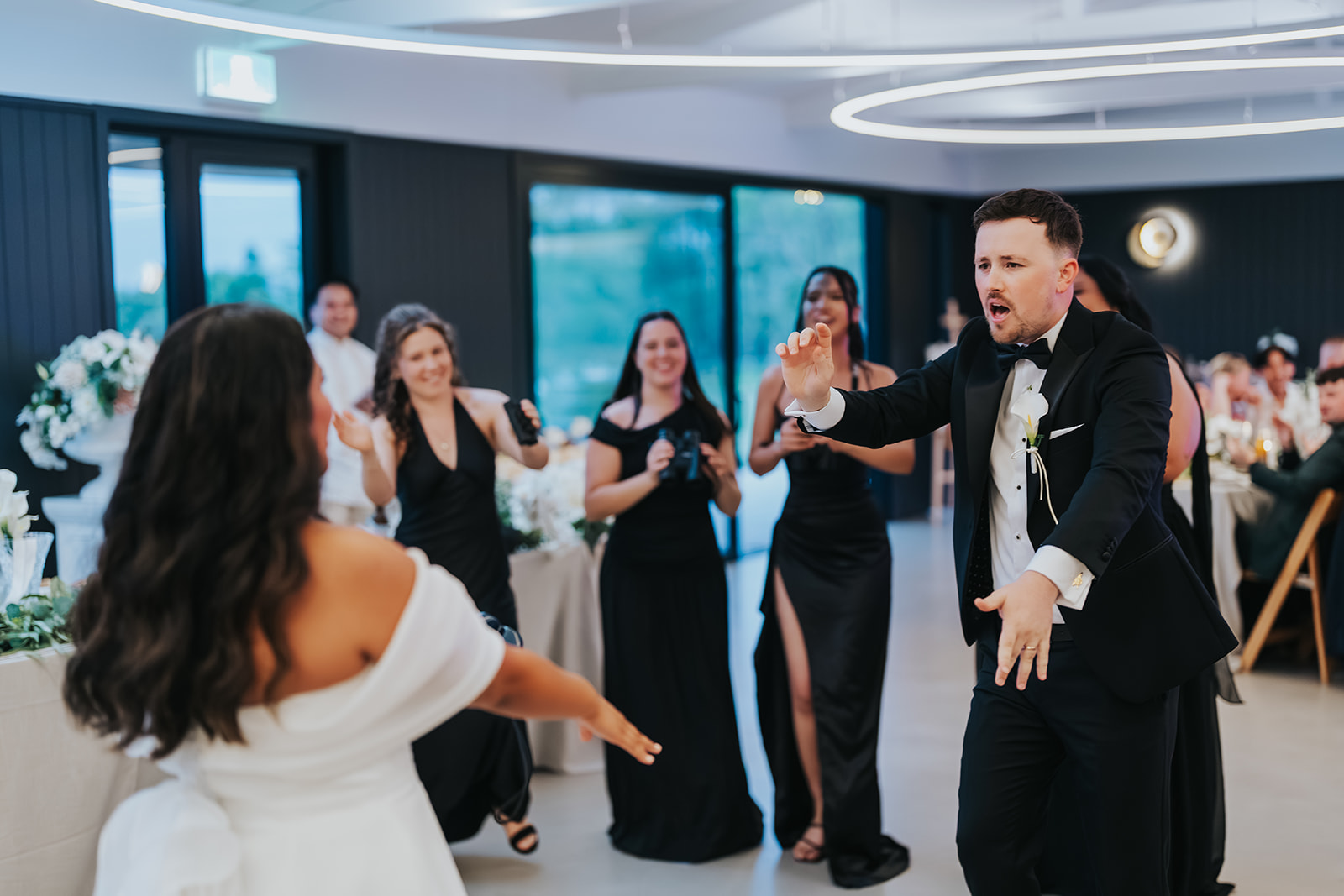 Bridesmaids cheering as the couple dance in
