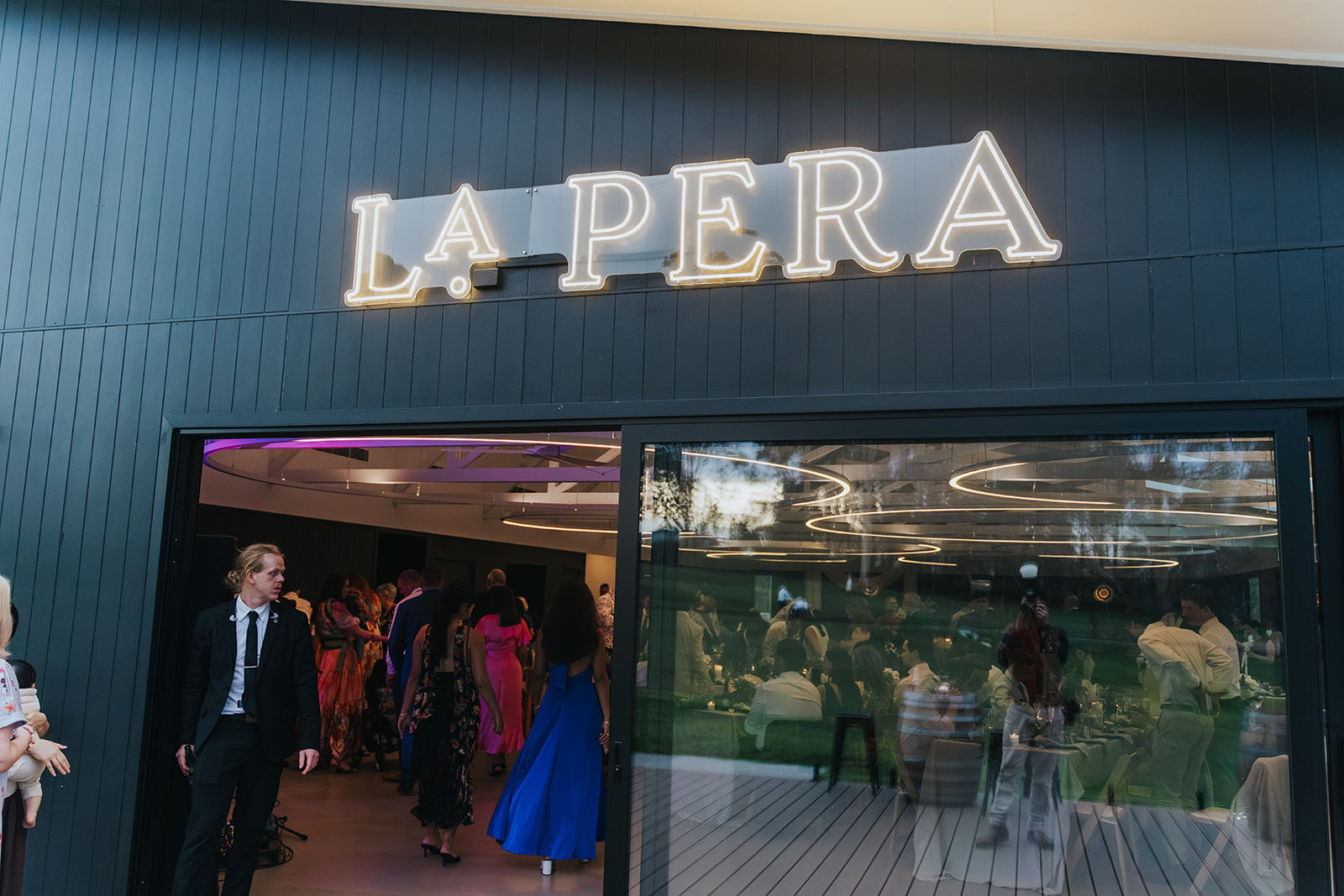 The illuminated La Pera sign at the entrance to the reception