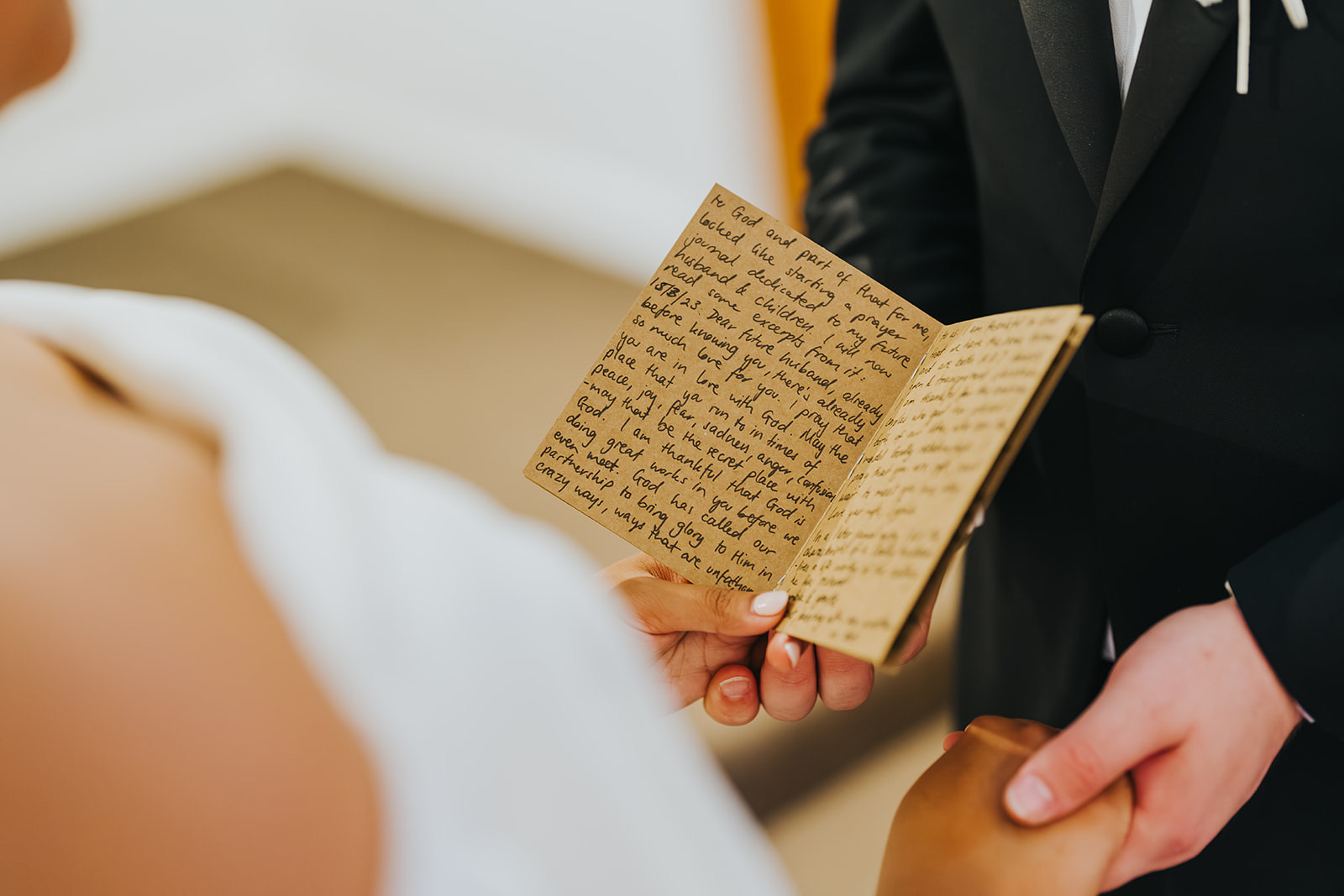 Close-up of the handwritten vow booklet in Lachlan's hands