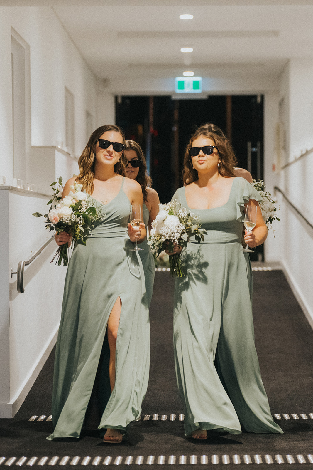 Two bridesmaids in sage gowns and sunglasses at Orso Bayside