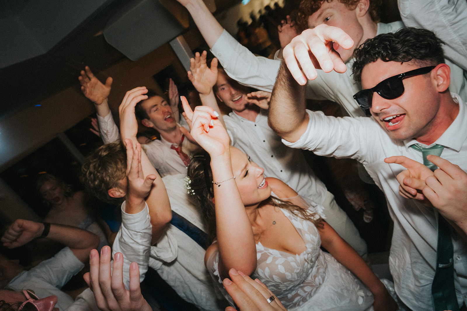 Friends lifting their hands on a packed dance floor at Orso Bayside