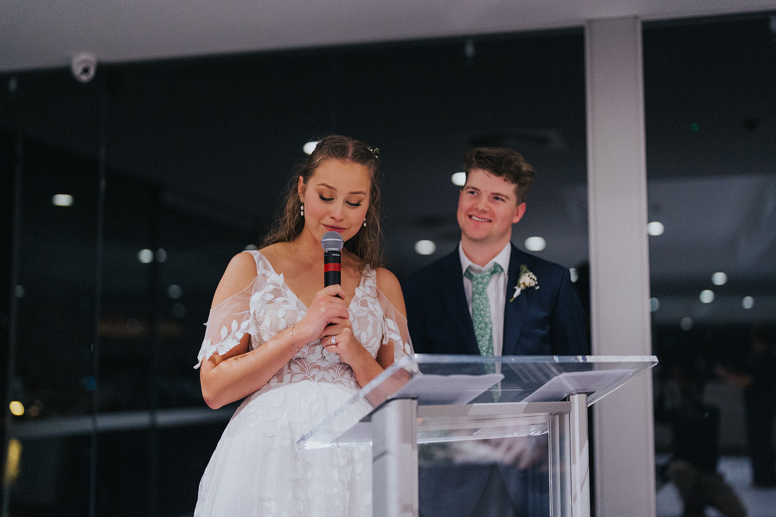 Naomi giving a speech beside Ben at the lectern