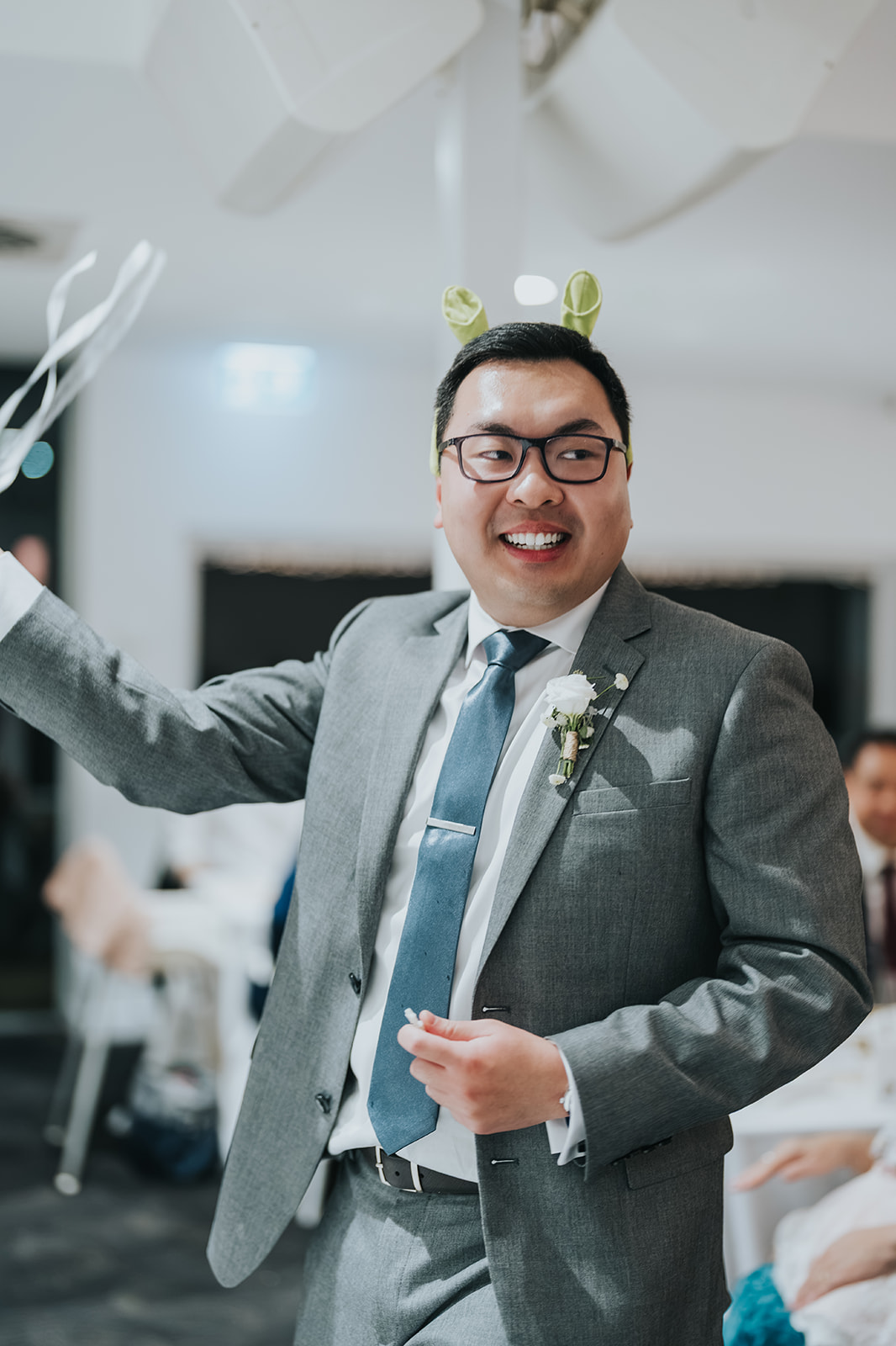 A groomsman laughing at the reception