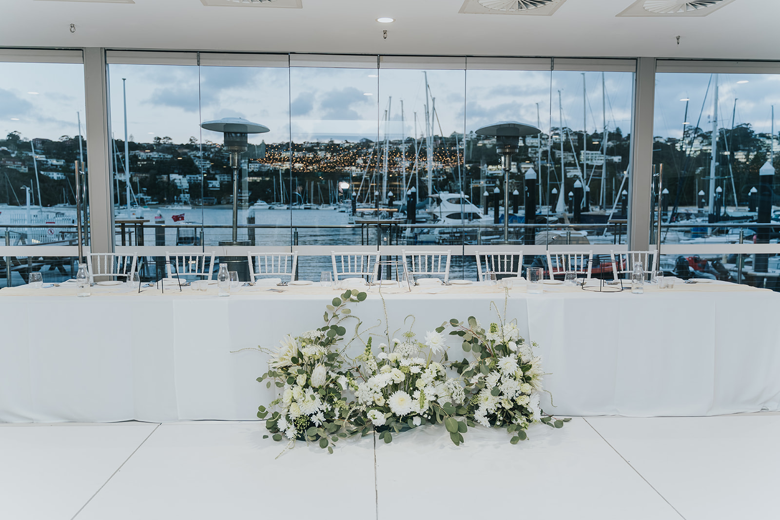 Bridal table at Orso Bayside with the Middle Harbour marina through the glass