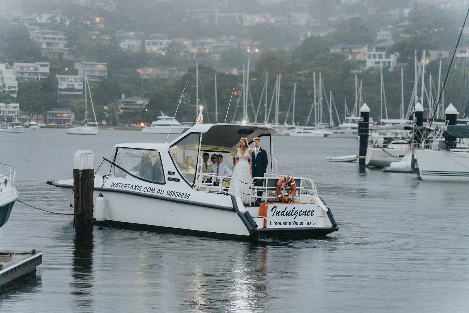 Newlyweds arriving by water taxi at the marina outside Orso Bayside