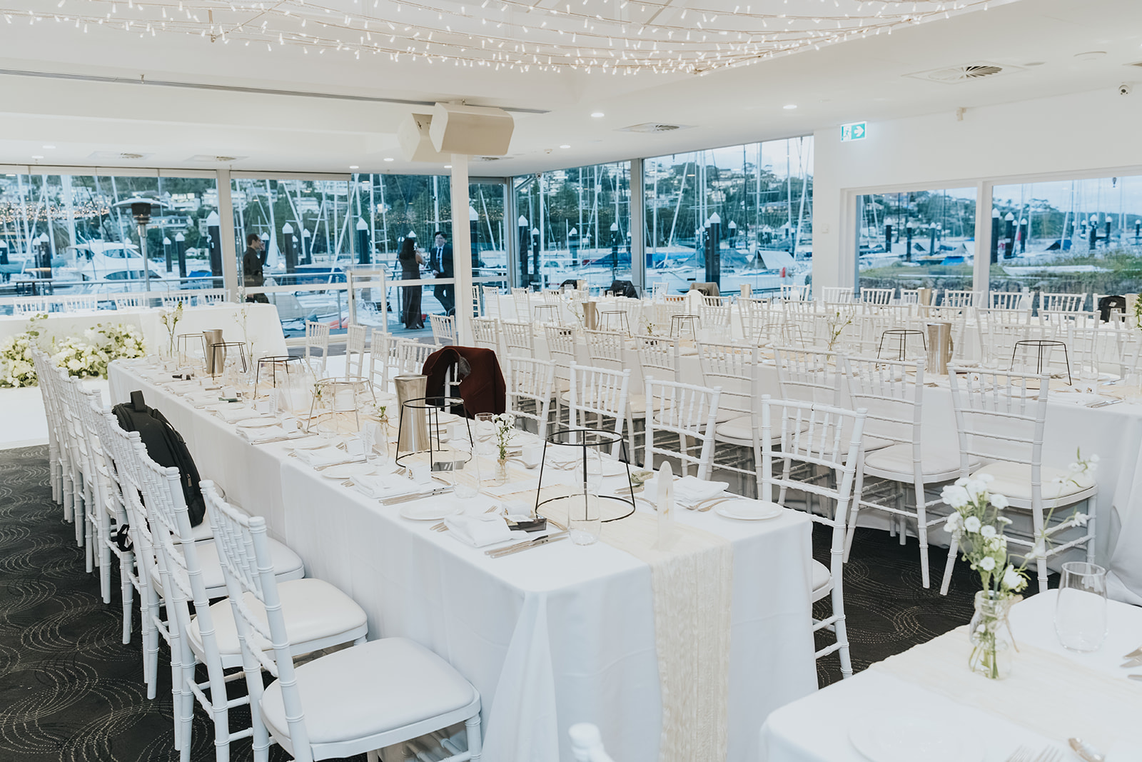 Open-plan reception room at Orso Bayside with the marina through the windows