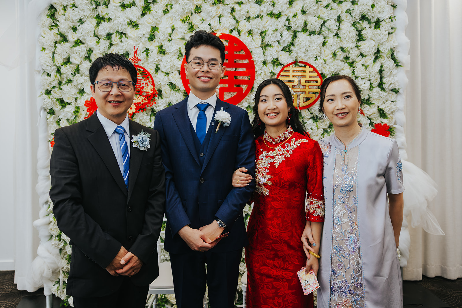 Rabi and Shaphir with family in front of the tea ceremony backdrop