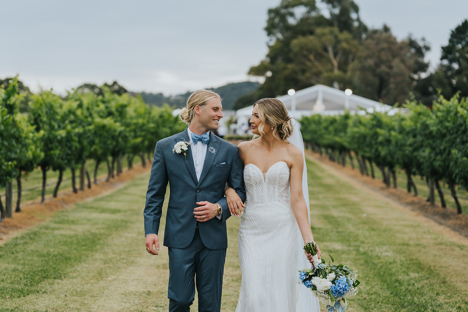 Newlyweds walking through a vineyard