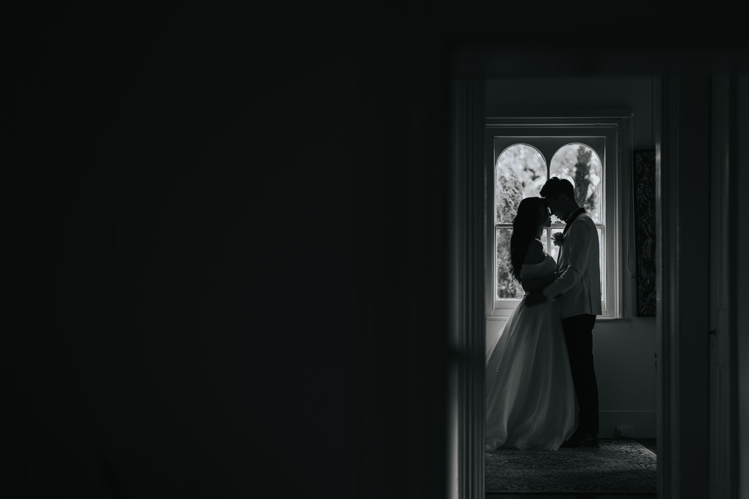 Couple silhouetted in an arched window through a doorway